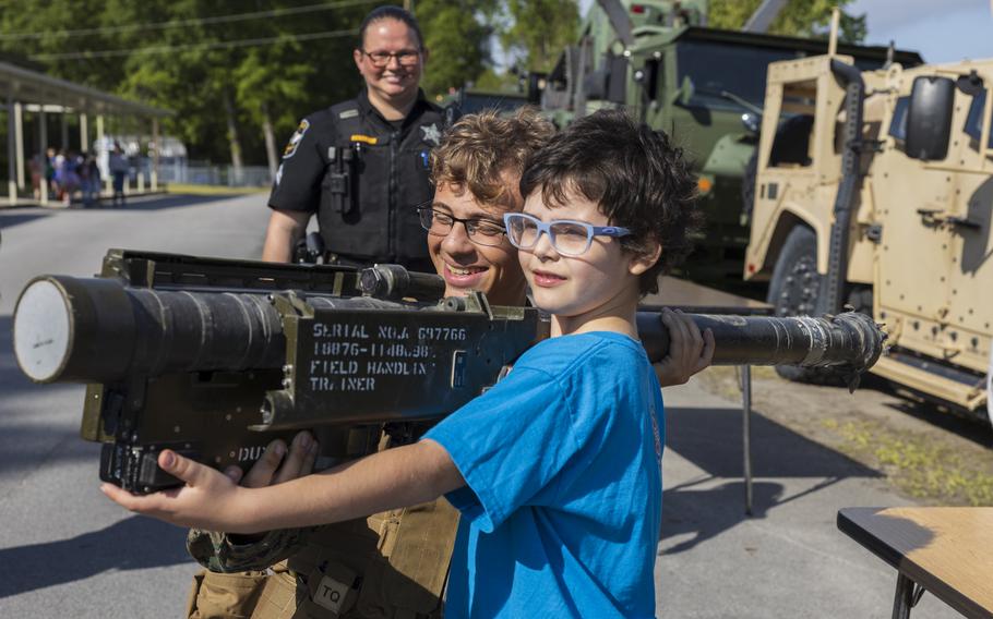 U.S. Marine Corps Pfc. Joshua Teague, center, a native of Tennessee and a low-altitude air-defense (LAAD) gunner with 2nd LAAD Battalion, explains how to operate a FIM-92 Stinger to a student during a career fair at Oaks Road Academy in New Bern, N.C., Friday, April 19, 2024. 