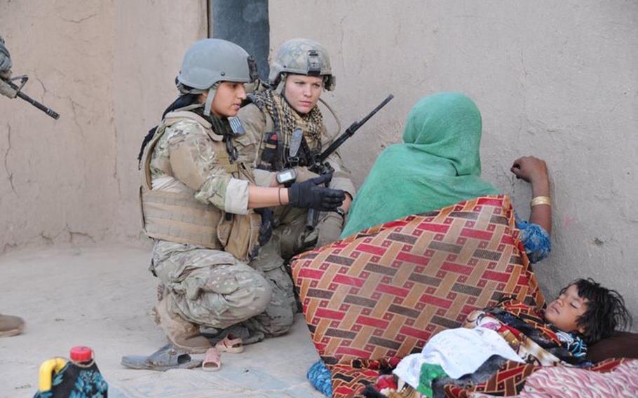 Jaclyn “Jax” Scott, center, speaks with an Afghan woman in 2012.