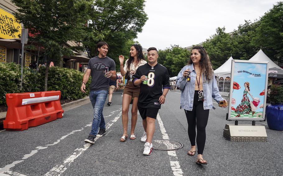 From left, Spiro Tsianakas, Theoni Tsinonis, Nektarios Tsinonis, and Anastasia Kontos stroll along Woodmont Avenue in Bethesda, Md.