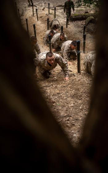 Marine low crawl under barbed wire.