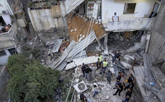 Palestinians inspect a damaged building following an Israeli army raid in Nour Shams refugee camp in the northern West Bank, Sunday, Sept. 24, 2022. 