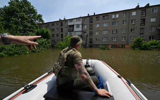 Servicemen of the National Guard of Ukraine sail on boat as they deliver food to the residents of a flooded area in Kherson on June 8, 2023, following damages sustained at Kakhovka hydroelectric power plant dam. Ukraine and Russia accused each other of shelling in the flood-hit Kherson region on June 8, 2023, even as rescuers raced to save people stranded after the destruction of a Russian-held dam unleashed a torrent of water. (Genya SAVILOV/AFP/Getty Images/TNS)