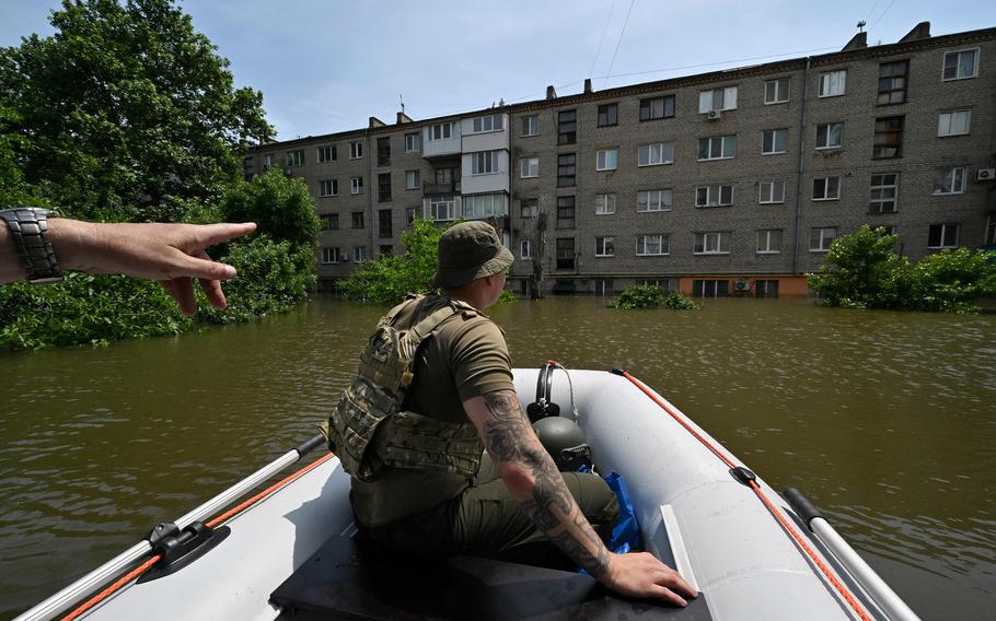 Servicemen of the National Guard of Ukraine sail on a boat as they deliver food to the residents of a flooded area in Kherson on June 8, 2023, following damages sustained at Kakhovka hydroelectric power plant dam. Ukraine and Russia accused each other of shelling in the flood-hit Kherson region on June 8, 2023, even as rescuers raced to save people stranded after the destruction of a Russian-held dam unleashed a torrent of water.