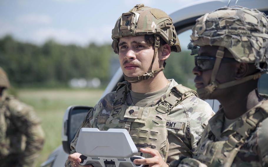 A U.S. soldier controls a Skydio X10D drone outfitted with an M67 dummy grenade.