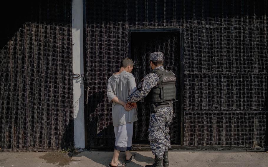 A police officer takes a man into the provisional detention center “El Penalito” in San Salvador on Tuesday. 