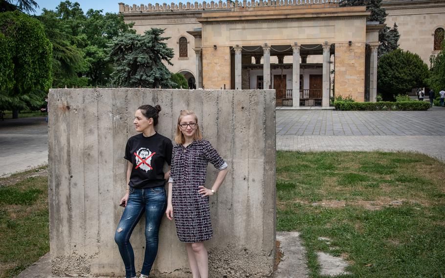 Teona Pankvelashvili, wearing a T-shirt with Stalin's face crossed out, and Nino Dalakishvili pose in front of empty pedestal outside the Stalin Museum in Gori, Georgia, on May 18, 2021. They are part of a group of local activists that prevented the restoration of the statue. 