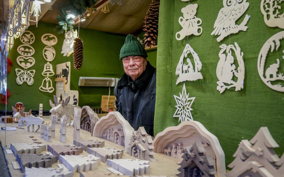 Vender Nils Knauerbstnads stands in his booth at the Christmas market in central Frankfurt, Germany, Tuesday, Nov. 23, 2021.