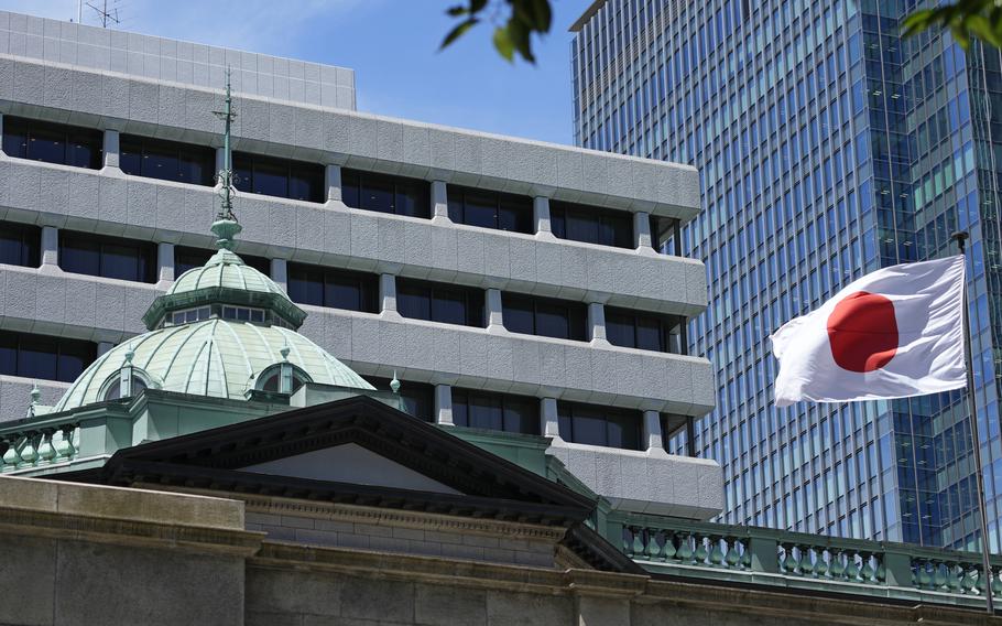 A Japanese flag flutters at the Bank of Japan headquarters in Tokyo, on July 29, 2022. A key Japanese central bank report said that sentiment among big manufacturers has sagged but that optimism is at a three-decade high among large business outside the manufacturing sector.