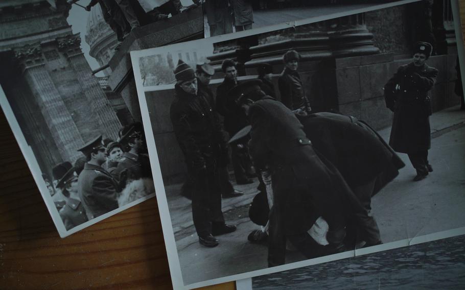 Photos displayed at the home of Yuly Rybakov in St. Petersburg on Dec. 15, 2022. According to Rybakov, this picture shows Russia's future president, Vladimir Putin, bending over and watching police detain a person.