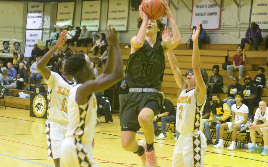 Kubasaki’s Troy Harris drives between Kadena defenders during Friday’s Okinawa boys basketball game. The Panthers won 49-44, completing a four-game season-series sweep of the Dragons.