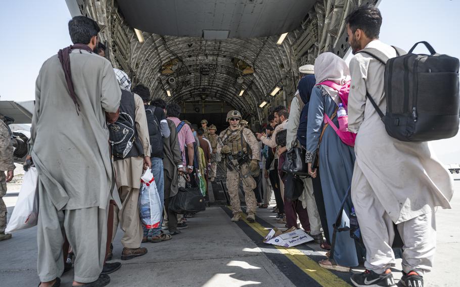 U.S. airmen and U.S. Marines guide qualified evacuees aboard a U.S. Air Force C-17 Globemaster III in support of the Afghanistan evacuation at Hamid Karzai International Airport (HKIA), Afghanistan, Aug. 21, 2021.