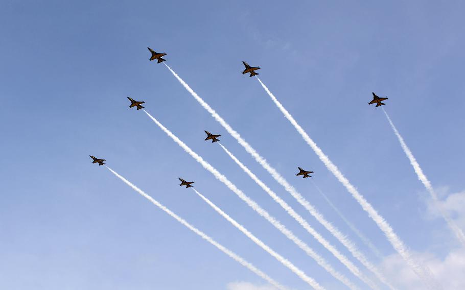 Jets fly across a blue sky.