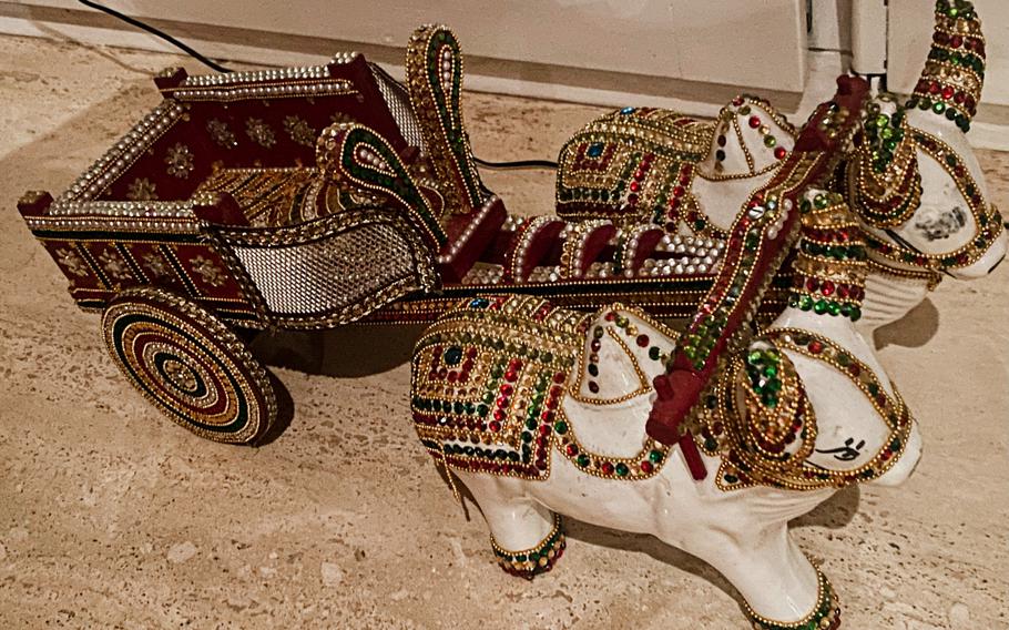 A figurine of bulls pulling a cart adorns a windowsill at Curry House, an Indian restaurant in Kaiserslautern, Germany. Among other animal depictions in the decor are small, gold-colored elephant statues.