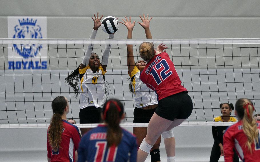 Vicenza's Alexandra Taylor, center right, and Kaylah Starling go up to block an attack by Aviano's Addison Krajicek during a semifinal match at the DODEA European volleyball championships on Oct. 27, 2023, at Ramstein High School on Ramstein Air Base, Germany.