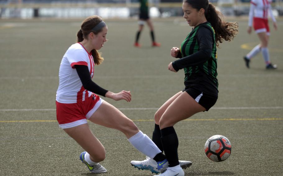 Nile C. Kinnick's Victoria Justice sends the ball between the legs of Robert D. Edgren's Aliyah Torres during Saturday's DODEA-Japan girls soccer match. The Red Devils blanked the Eagles 5-0.