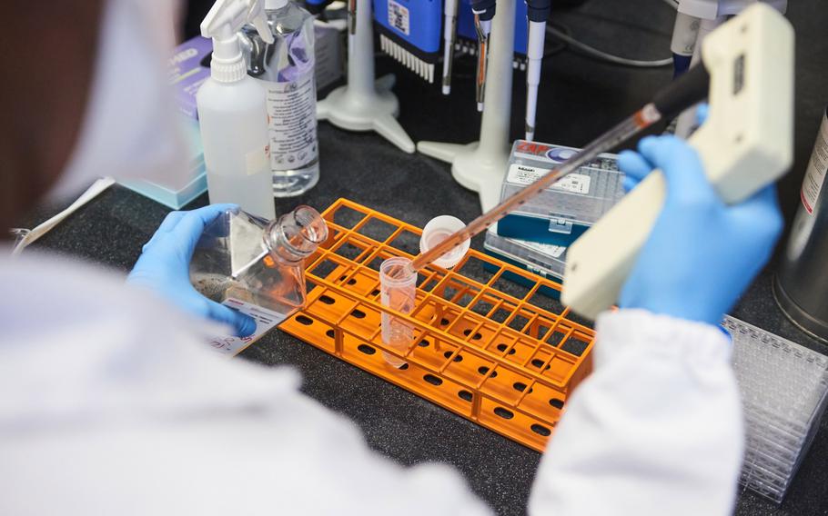 A technician uses a single channel pipette dropper to dispense material during COVID-19 antibody neutralization testing in a laboratory at the African Health Research Institute in Durban, South Africa, on Dec. 15, 2021.