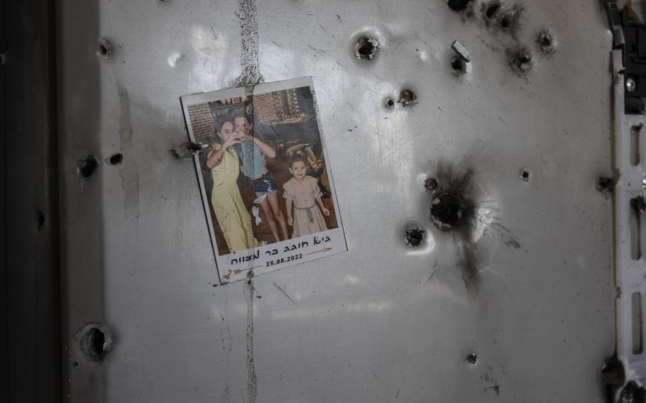 A family photograph of a bar mitzvah on a refrigerator riddled with bullet holes in a home in Kibbutz Kissufim, Israel, on Oct. 18. Hamas militants attacked the kibbutz on Oct. 7, killing at least eight civilians and six Thai laborers while as many as four people were abducted and taken to Gaza.