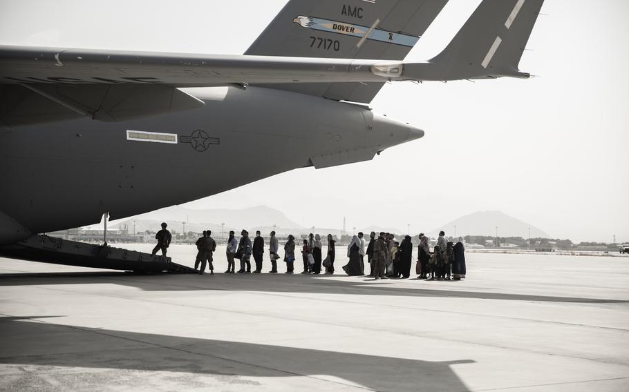 Evacuees wait to board a Boeing C-17 Globemaster III during at the airport in Kabul, Afghanistan, on Aug. 30, 2021. Approximately 124,000 Afghans were airlifted to safety in one of the largest air evacuations of civilians in American history.