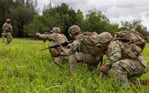 U.S. Army Chaplain Capt. Juan Castro (right), Cpl. Jacob Torres (center), a religious affairs specialist, both with the 2nd Squadron, 6th Cavalry Regiment, 25th Combat Aviation Brigade, 25th Infantry Division react to small arms fire while moving with an infantry squad at East Range on Schofield Barracks, Hawaii, Feb. 1, 2024. Reacting to contact was one of five training stations where unit ministry teams were evaluated on their ability to operationalize religious support in a large-scale combat environment. (U.S. Army photo by Sgt. Jared Simmons, 28th Public Affairs Detachment)