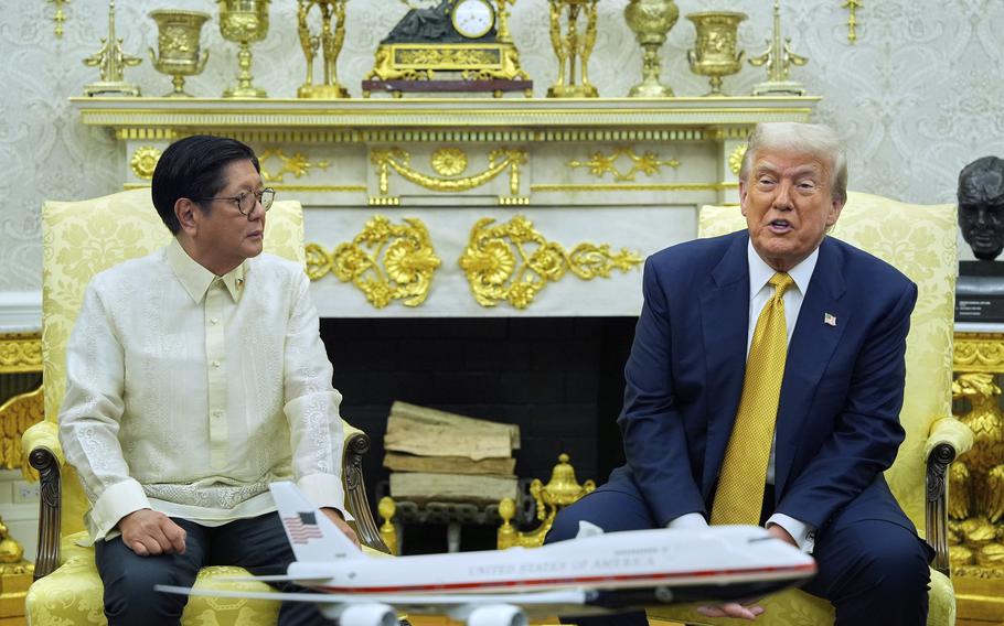 The president of the Philippines in a light dress shirt, sitting next to President Donald Trump in a blue suit.