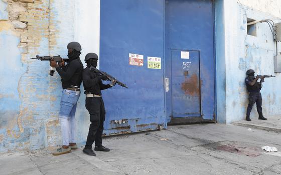 National Police stand guard outside the empty National Penitentiary after a small fire inside in downtown Port-au-Prince, Haiti, Haiti, Thursday, March 14, 2024. This is the same facility that armed gangs stormed late March 2 and hundreds of inmates escaped. (AP Photo/Odelyn Joseph)