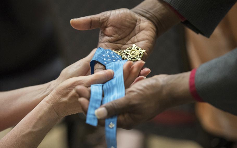 Army civilian employees pass around retired Master Sgt. Leroy Petry's Medal of Honor in May 2018 as he spoke at an event at Rock Island Arsenal in Illinois.