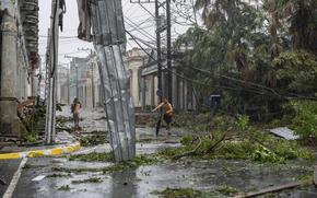 Fallen electricity lines, metal and tree branches litter a street after Hurricane Ian hit Pinar del Rio, Cuba, Tuesday, Sept. 27, 2022. 