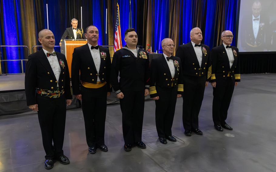 Sailors stand in a line at attention during a ceremony