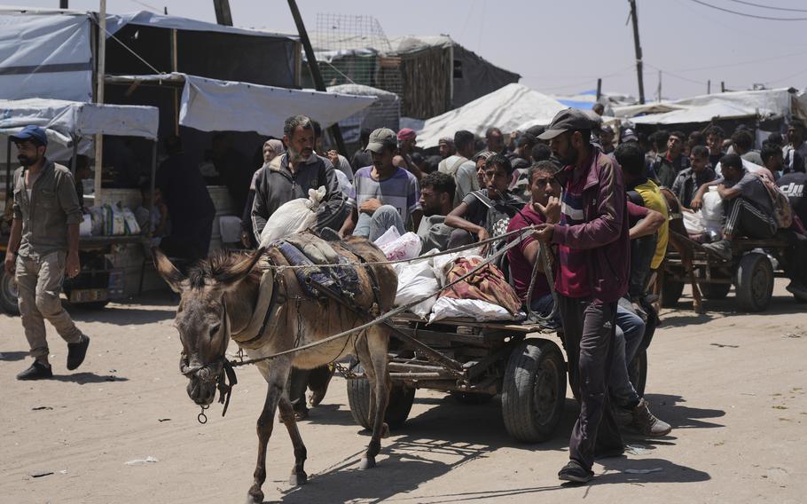 People and bags are towed by a small carriage pulled by a donkey.