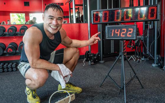 A sweat-soaked Oregon Army National Guard Physician Assistant Maj. Tommy Vu points to the counter displaying 1,422 repetitions after completing his world record attempt for most hand release push-ups in one hour at West Coast Strength gym in West Salem, Ore., May 23, 2025. Vu's achievement marks his seventh world record and is pending official verification by Guinness World Records. (U.S. Army National Guard photo by Maj. W. Chris Clyne, Oregon National Guard Public Affairs)