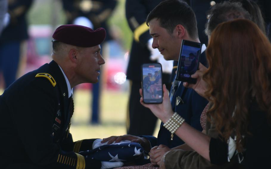 Maj. Gen. Christopher C. LaNeve, Commanding General of the 82nd Airborne Division, left, presents the U.S. flag to J. Trace Megellas, grandson of Lt. Col. James Megellas.