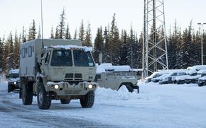 A Light Medium Tactical Vehicle and a High Mobility Multipurpose Wheeled Vehicle leaves the Alaska National Guard Armory on Joint Base Elmendorf-Richardson, Alaska, for transport to the Alcantra Armory in Wasilla, Jan. 5. The LMTV and HMMWV have been assigned to Alaska Army National Guard's 297th Regional Support Group to provide direct support to the Matsu-Borough after high winds have led to infrastructure damage, power outages, and dangerous transportation conditions. (U.S. Army National Guard photo by Victoria Granado)