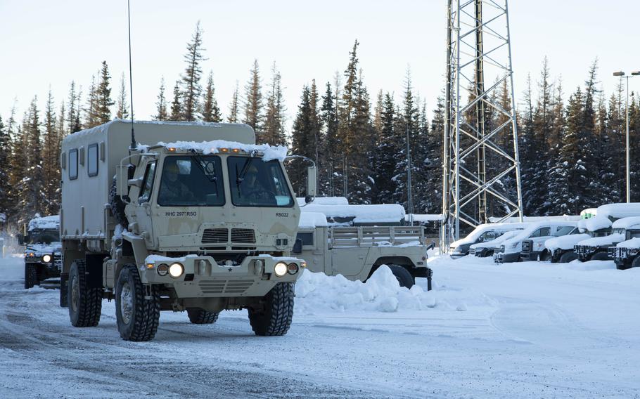 A Light Medium Tactical Vehicle and a High Mobility Multipurpose Wheeled Vehicle leave the Alaska National Guard Armory on Joint Base Elmendorf-Richardson, Alaska, Jan. 5, 2022. 