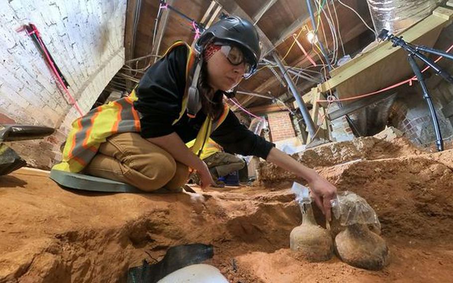 Archaeologist Tess Ostoyich carefully exposes two intact mid-18th century bottles in the Mansion cellar at George Washington’s Mount Vernon. The bottles still had, along with liquid, some of the cherries they contained when they were buried about 250 years ago. Much of the liquid could be ground water that seeped in after the cork seals deteriorated, but pits, stems, sodden cherries and gooey residue were also present, experts said.