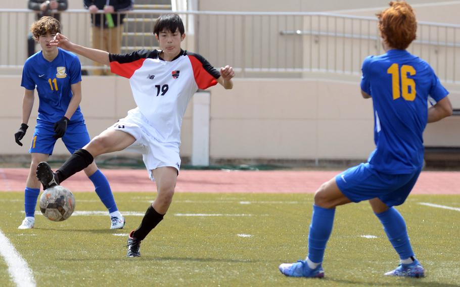 Nile C. Kinnick's Luis Galloway tries to settle the ball between Yokota's Senna Solberg and Alex Kosinski during the championship match in the Perry Cup soccer tournament. The Red Devils shut out the Panthers 2-0.