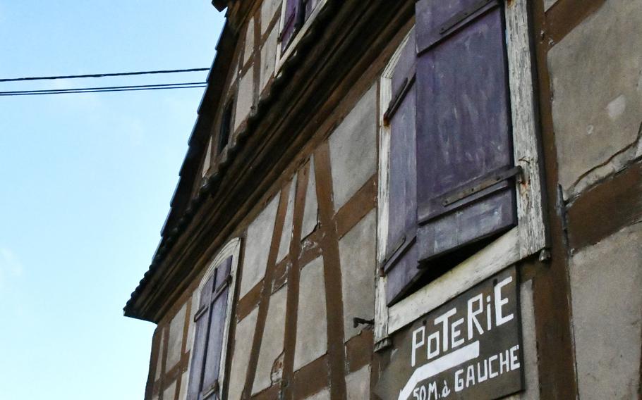 A handpainted sign on a half-timbered building in Soufflenheim, France, indicates there’s a pottery workshop 50 meters away on the left. Soufflenheim is known for its traditional Alsatian pottery.