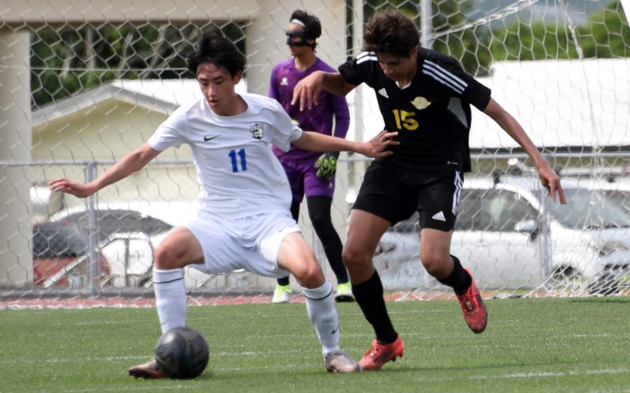 CAJ's Kei Arnold and Kadena's Elias Cedeno scrap for the ball.
