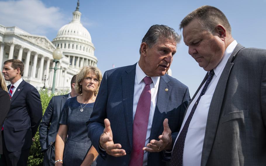 Sen. Joe Manchin, D-W.Va., speaks to Sen. Jon Tester, D-Mont., right, during a news conference on Capitol Hill last July.