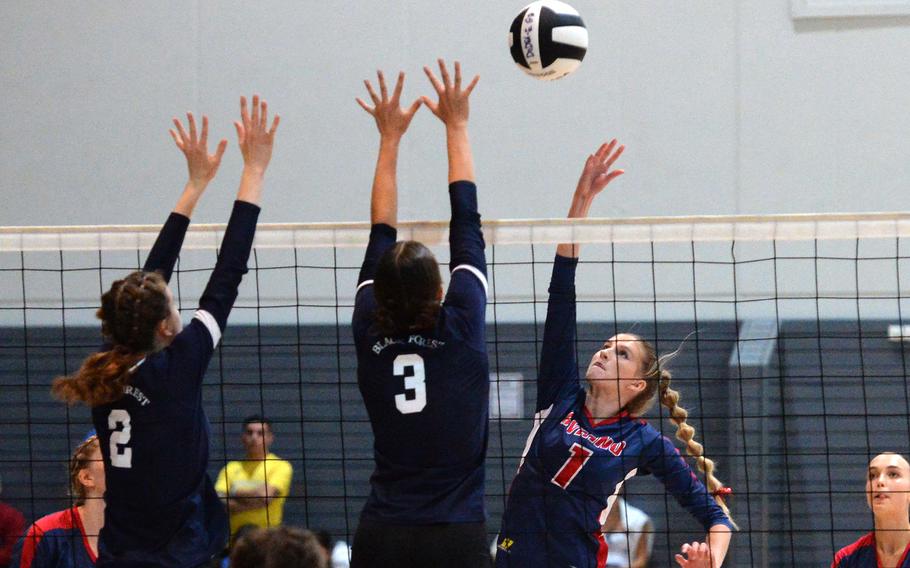 Aviano’s Jaycee Spence hits the ball over Black Forest Academy defenders Danielle Cherry, left, and Kalista White in the Division II final of DODEA-Europe volleyball championships in Ramstein, Germany. The Saints took the title with a 25-19, 25-21, 24-26, 25-23 win over BFA.