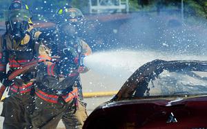 U.S Air Force Senior Airmen Brandon Young and Wesley Martin, 20th Civil Engineer Squadron firefighters, extinguish a controlled car fire using compressed air foam at Shaw Air Force Base, S.C., March 10, 2014. The 20th CES firefighters were training with a new CAF system, which makes the fire hose lighter and easier to use. (U.S. Air Force photo by Airman 1st Class Jensen Stidham/Released)