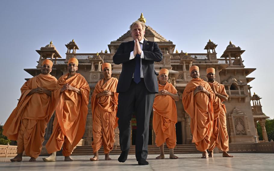 Britain's Prime Minister Boris Johnson, center, poses with Sadhus, or Hindu holy men, in front of the Swaminarayan Akshardham temple, in Gandhinagar, part of his two-day trip to India, Thursday, April 21, 2022. (Ben Stansall/Pool Photo via AP)