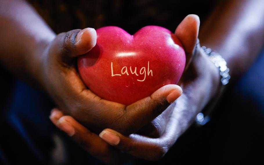 Ayana Brown, a Navy veteran, holds a a heart-shaped stone with the word “laugh” engraved in her meditation room at her home in San Antonio on Jan. 2, 2023. Brown is a participant of the culinary therapy program by The Pink Berets, a nonprofit that helps women service members and veterans suffering from post-traumatic stress disorder (PTSD), as well as mental and emotional trauma.