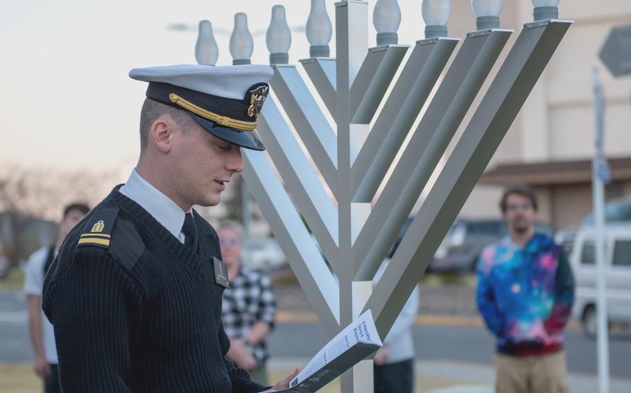 Chaplain (Lt. j.g.) Alex Hamilton offers a prayer at a menorah lighting ceremony at Yokosuka Naval Base, Japan, on Dec. 7, 2023.