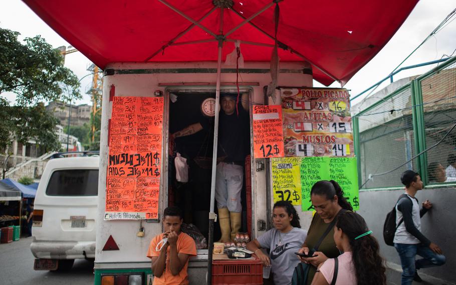Люди продают мясо на уличном рынке в общине Хосе Феликса Рибаса в районе Петаре в Каракасе, 5 ноября 2022 года. Венесуэльцы работают в неформальном и малом бизнесе в поисках альтернативного финансирования.  Кредиты составляют всего 1% ВВП из-за политики правительства по сдерживанию инфляции.  Частные компании для финансирования мелких предпринимателей появились в качестве альтернативы микрофинансированию.