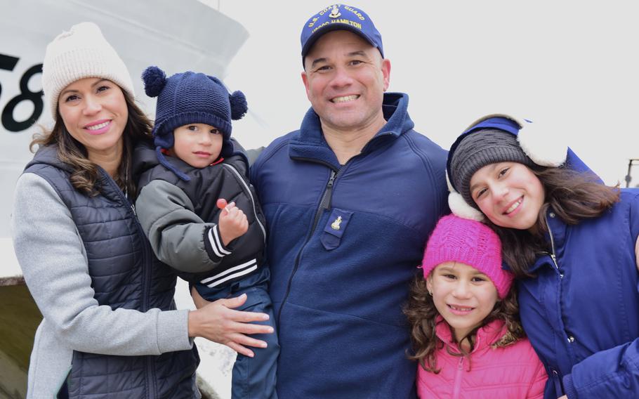 A USCGC Hamilton crew member and his family pose for a photo at the pier in North Charleston, S.C., Dec. 21. 2022. Hamilton completed a 94-day deployment in the Baltic Sea in support of U.S. 6th Fleet.