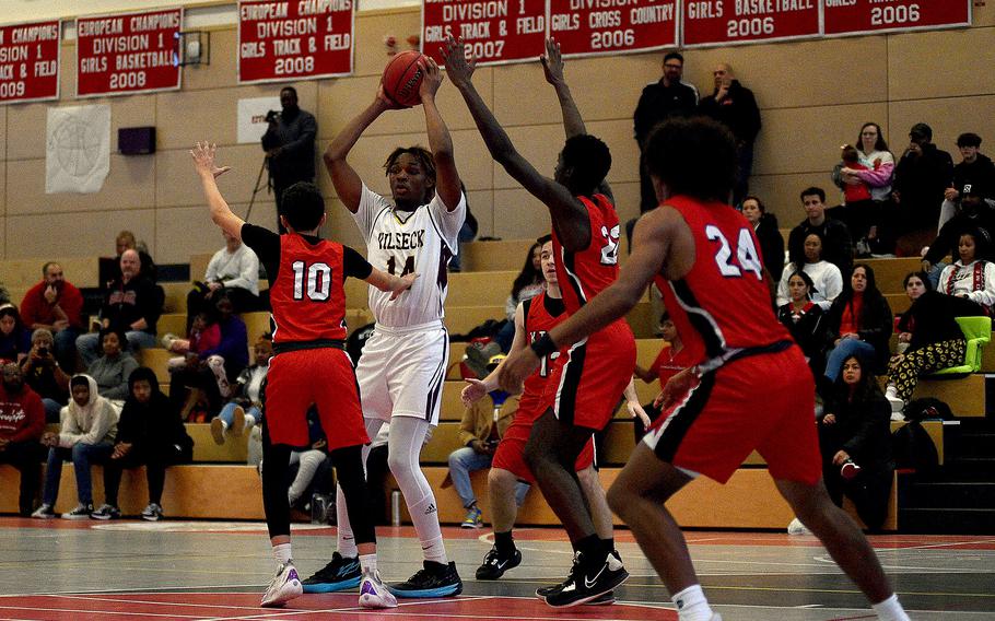 Vilseck's Barkale Johnson looks for a pass while being defended by Raiders Caleb Ringer, left, and Uray Dukuly, center,  during a Dec. 2, 2023, game at Kaiserslautern High School in Kaiserslautern, Germany