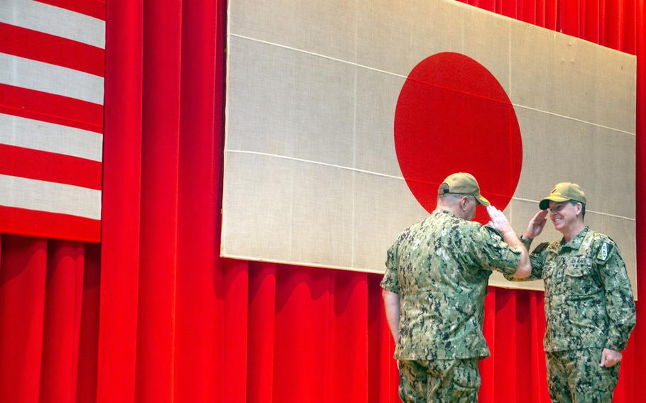 Rear Adm. Michael “Buzz” Donnelly, right, relieves Rear Adm. Will Pennington as commander of Task Force 70 and Carrier Strike Group 5 inside Benny Decker Theater at Yokosuka Naval Base, Japan, Thursday, Oct. 21, 2021. 