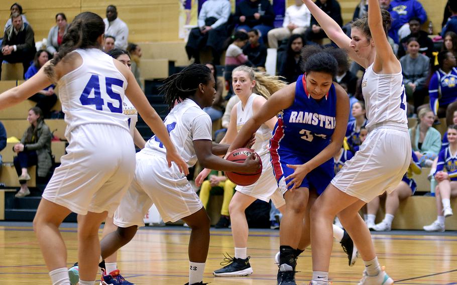 Ramstein's Alysha Edwards tries to dribble in the paint during the Royals' game Tuesday evening at Wiesbaden High School in Wiesbaden, Germany. Defending, from left, as the Warriors' Natalia Berdorf, Brandi Stanford and Lyndsey Urick.