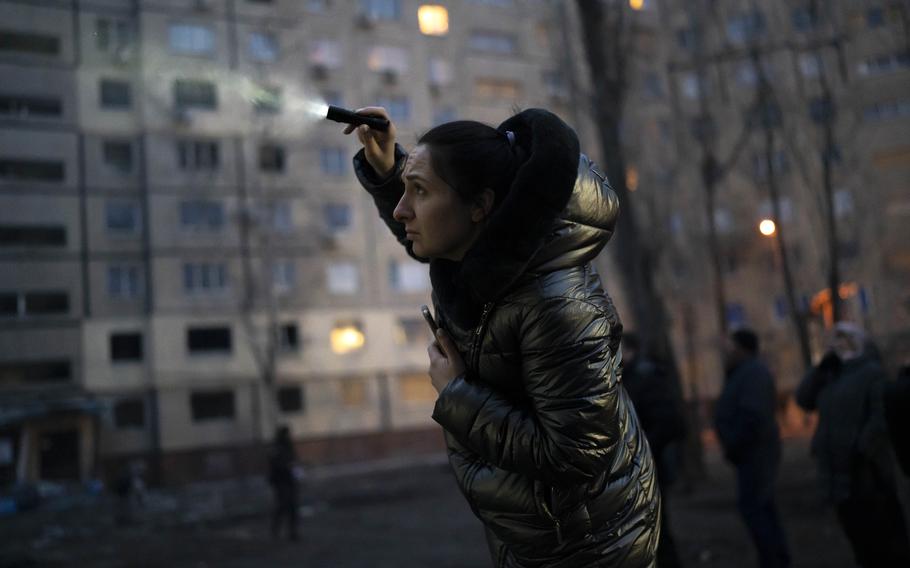 Nadiia Yaroshenko, 38, desperately trying to locate her cat with a flashlight in the damaged building on the edge to collapse in Dnipro, Ukraine, Tuesday, Jan. 17, 2023. 