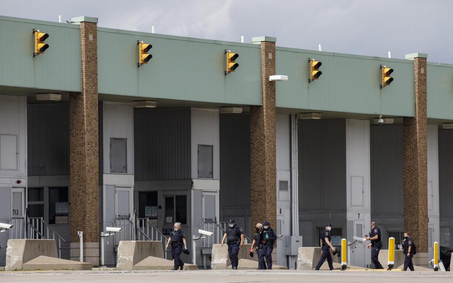 Border guards walk to their booths at the Ambassador Bridge in Windsor, Ontario, Canada, on May 26, 2021. 